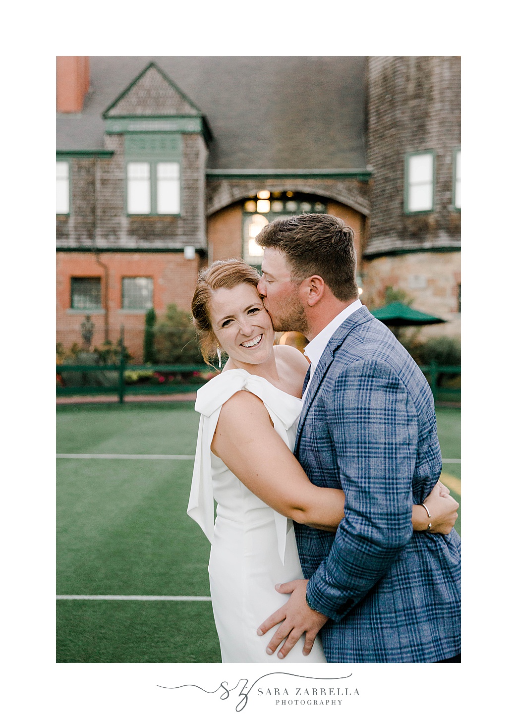 groom kisses bride's cheek during portraits at The International Tennis Hall of Fame