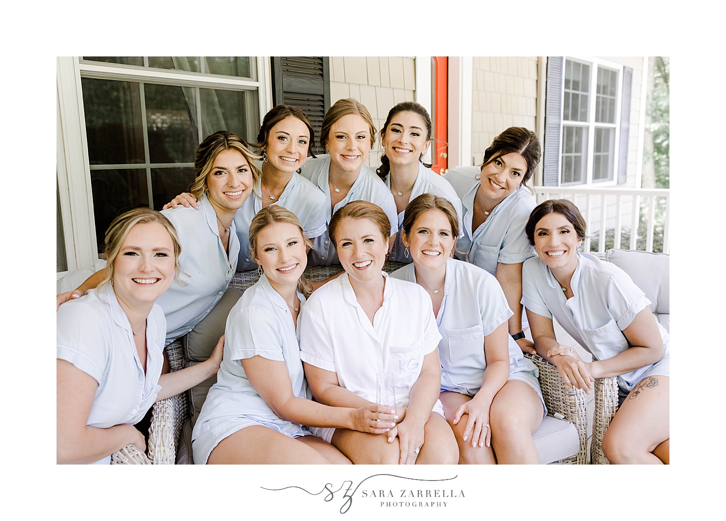 bride sits with bridesmaids in blue pajamas on front porch