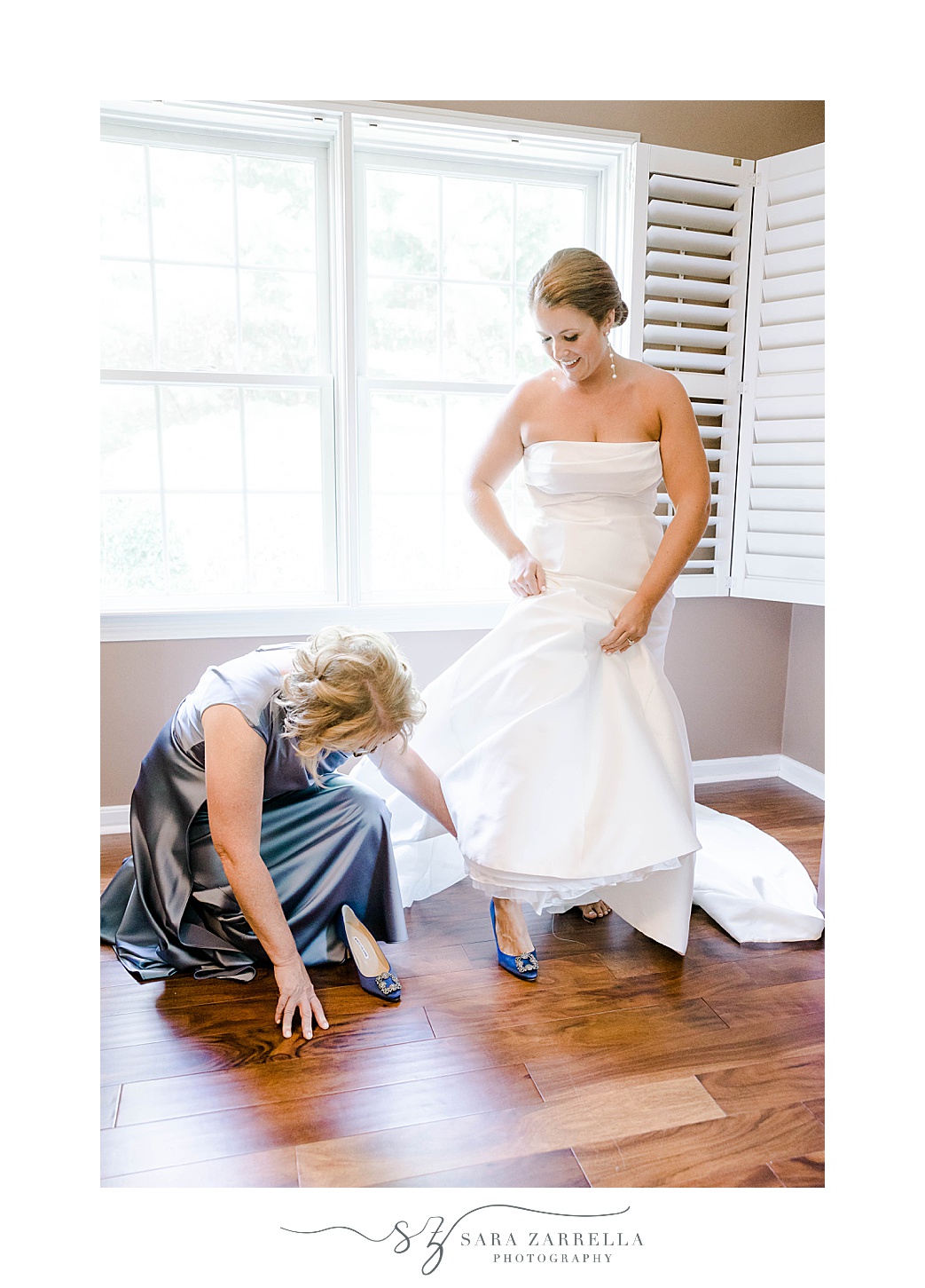 mother helps bride into shoes