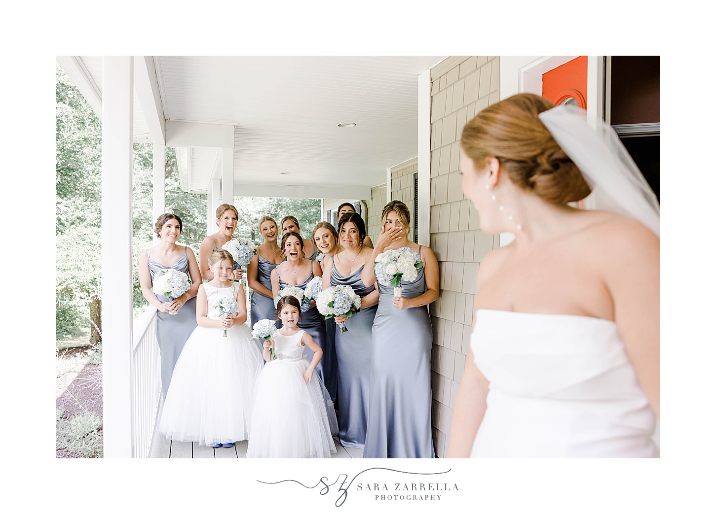 bride has first look with bridesmaids in blue gowns