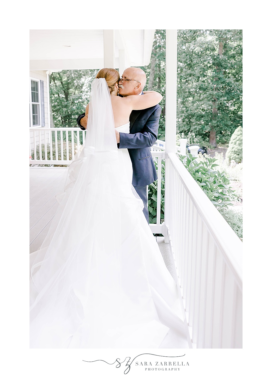 dad hugs bride on front porch after first look