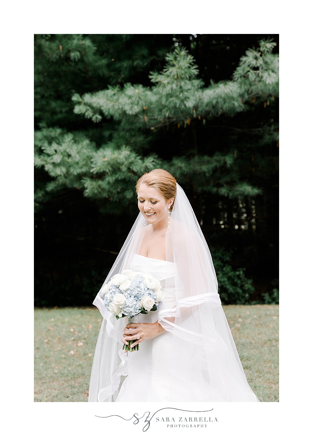 bride poses with veil around shoulders holding bouquet 