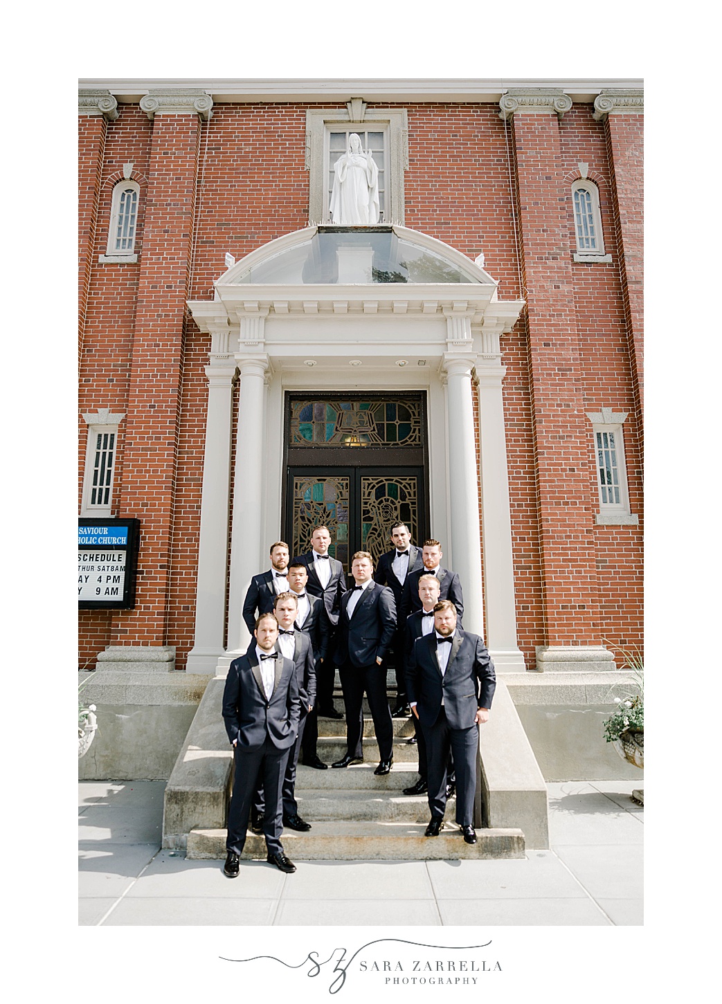 groom and groomsmen pose on steps of RI church