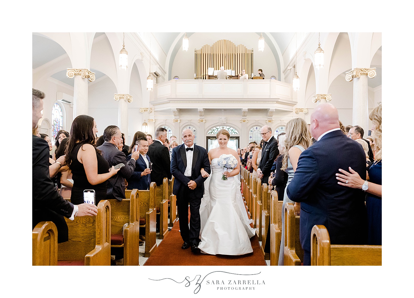 bride walks down aisle in church for wedding ceremony with dad