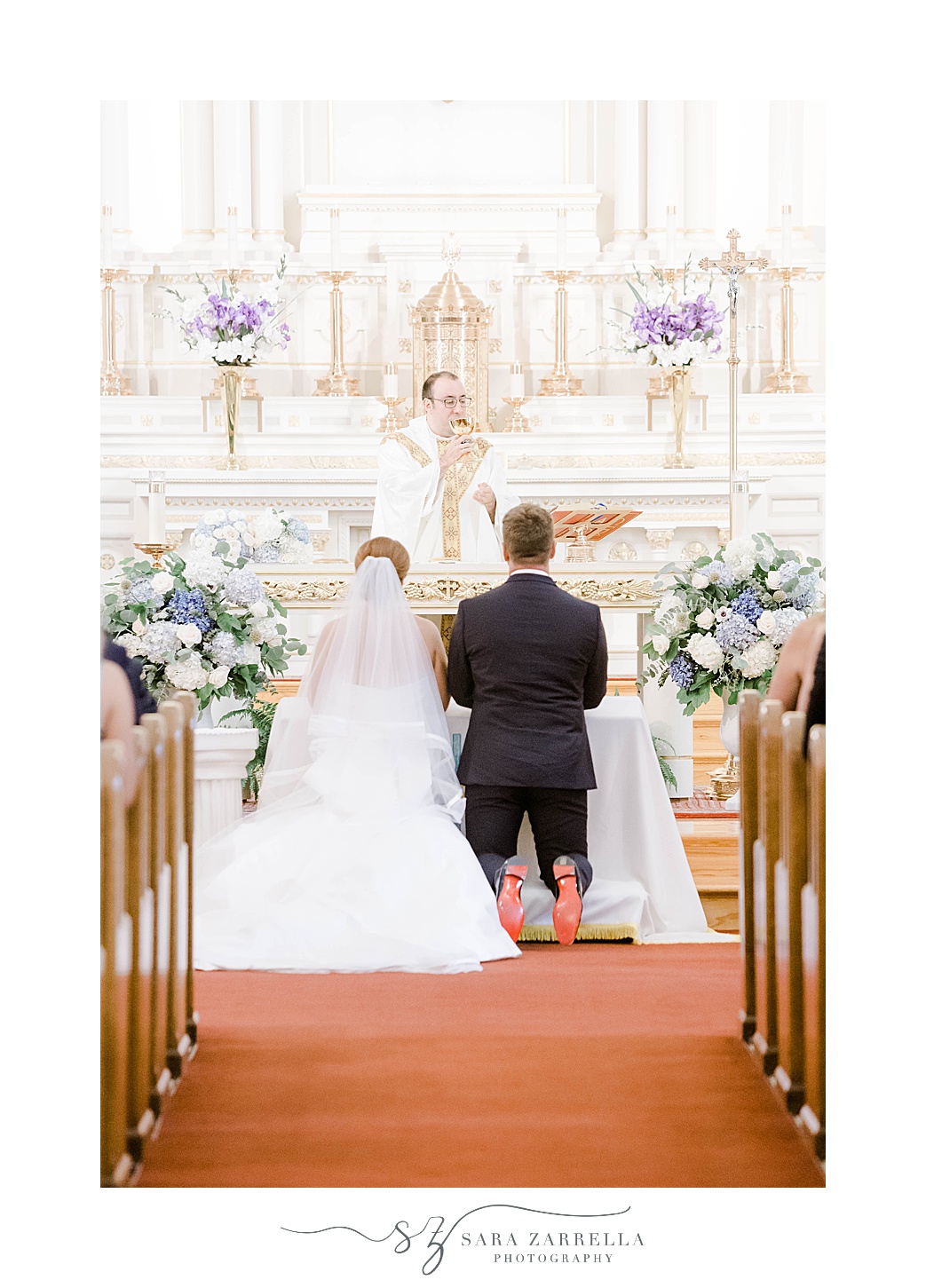 newlyweds kneel at alter during traditional church wedding in Rhode Island