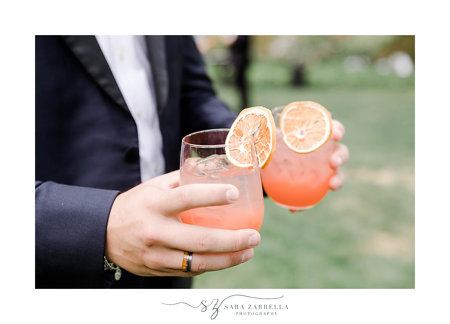 groom holds signature drinks with lemons 