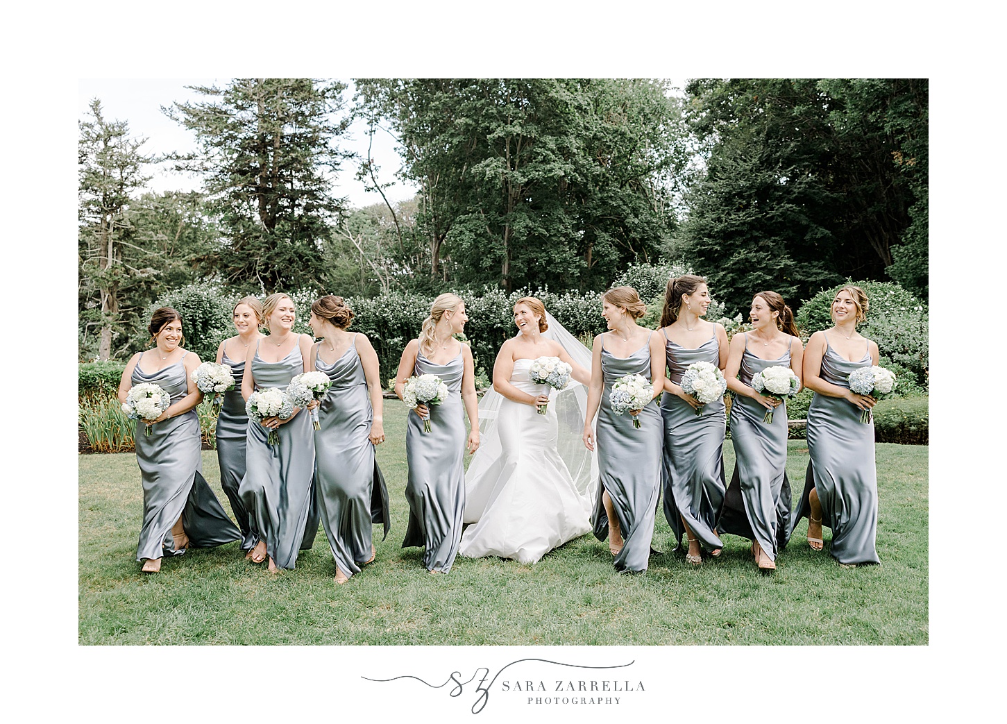 bride walks with bridesmaids in blue gowns