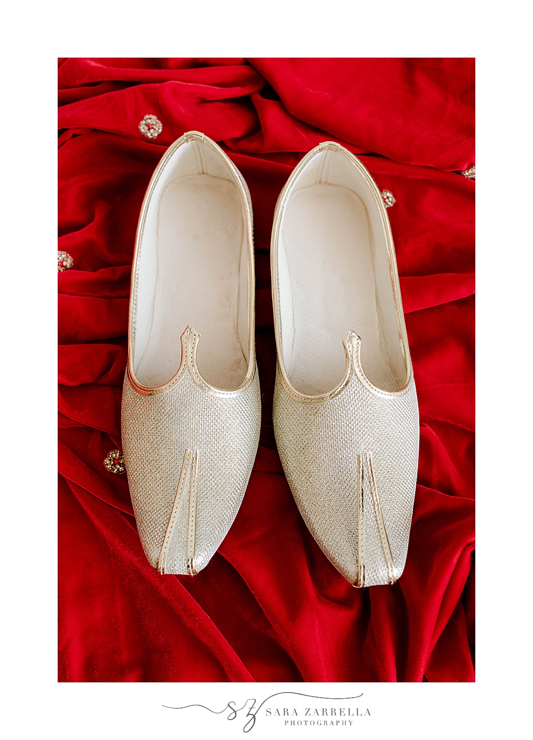 groom's ivory shoes on red robe