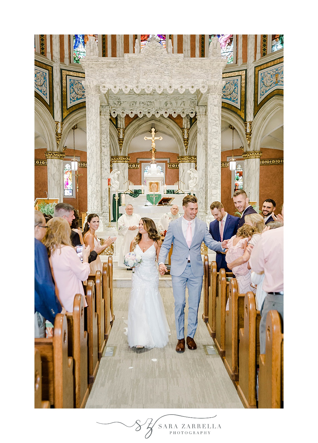 bride and groom walk up aisle after Catholic wedding ceremony in Newport RI