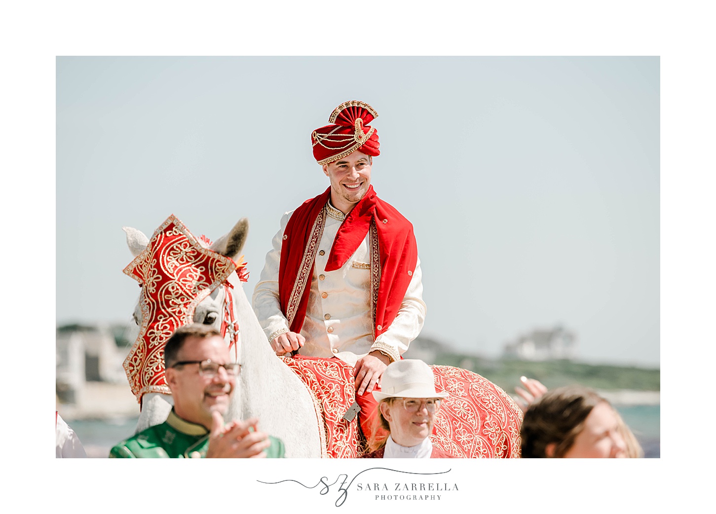 groom rides horse on Newport Beach during traditional Indian wedding ceremony