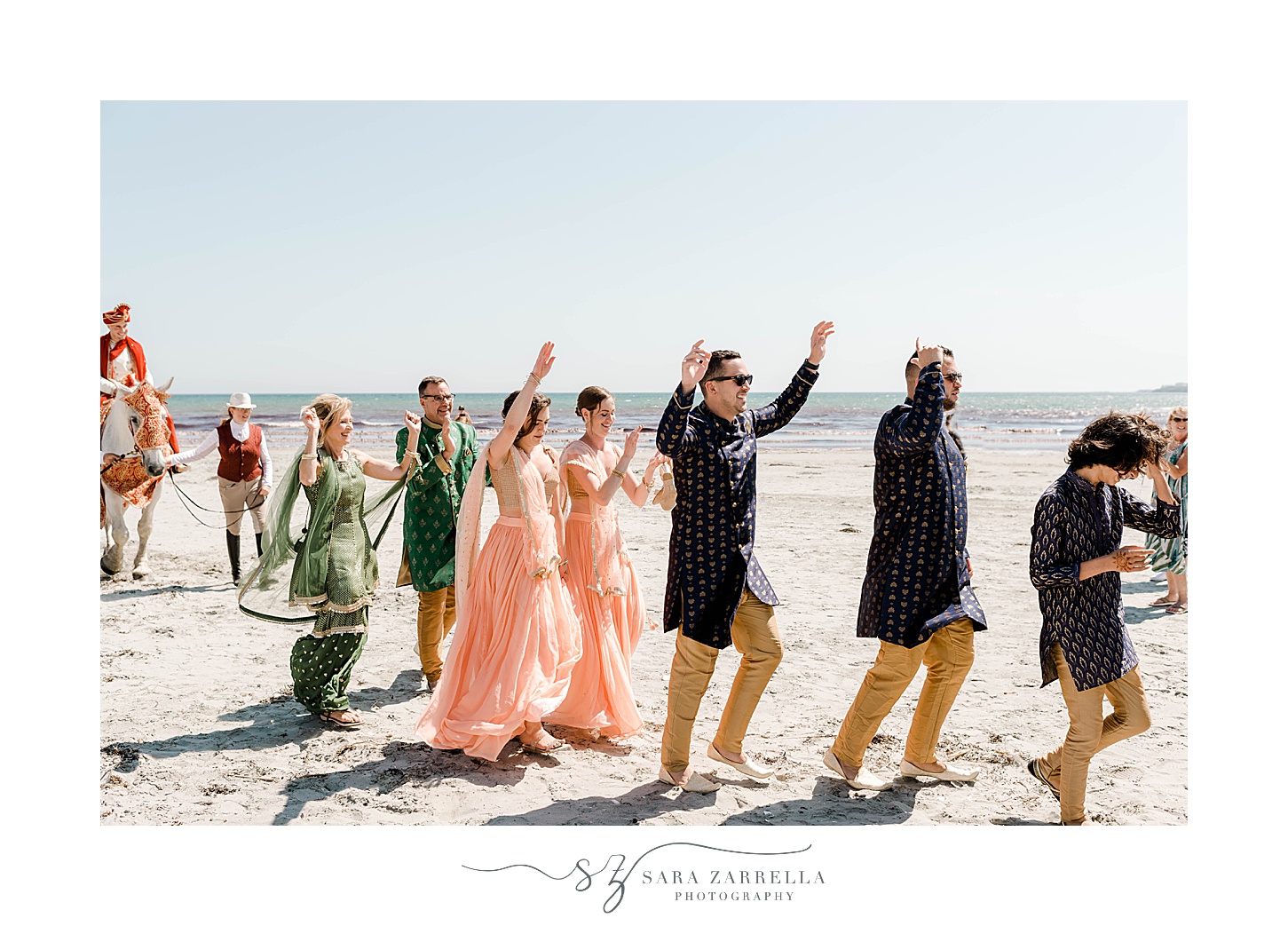 wedding guests dance across Newport Beach during traditional Indian wedding ceremony