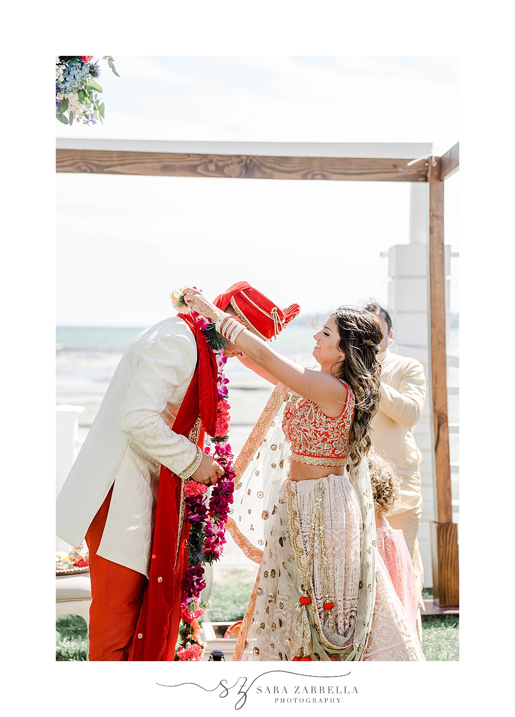groom puts necklace on groom during traditional Indian wedding ceremony at Newport Beach House