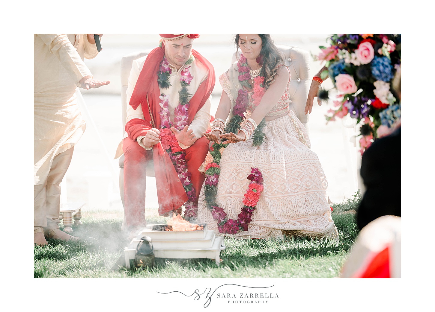 bride and groom sit by fire during traditional Indian wedding ceremony at Newport Beach House