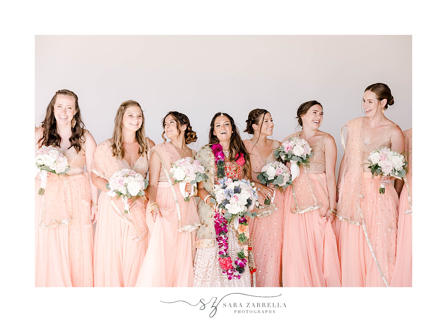 bride laughs with bridesmaids in pink dresses at Newport Beach House