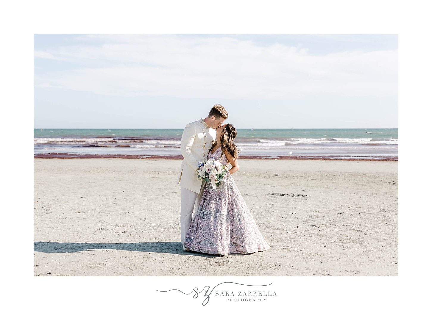 groom kisses bride in pastel saree on Newport Beach