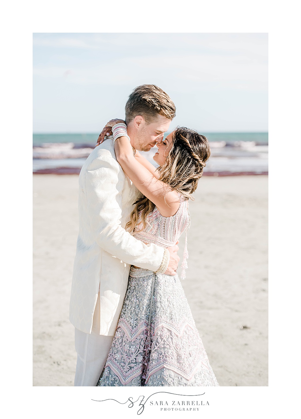 groom hugs bride in saree to him on Newport Beach
