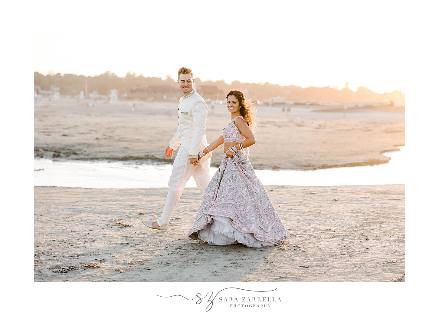 bride and groom hold hands walking on Newport Beach
