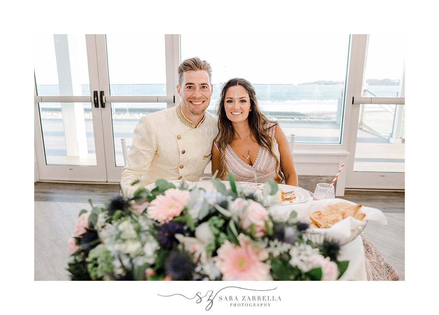 bride and groom sit at sweetheart table at Newport Beach House