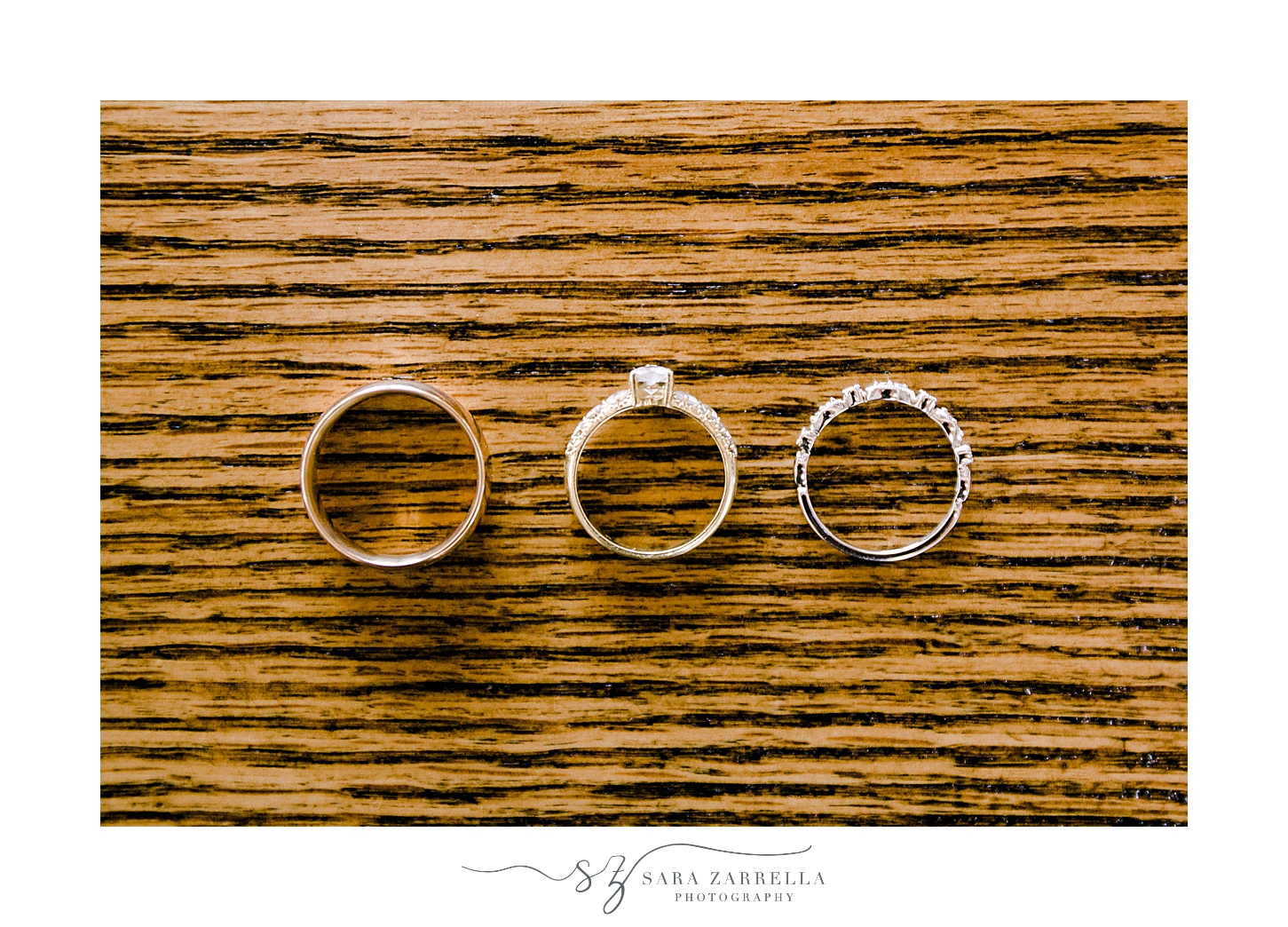 wedding rings rest on wooden table before Newport Vineyards wedding