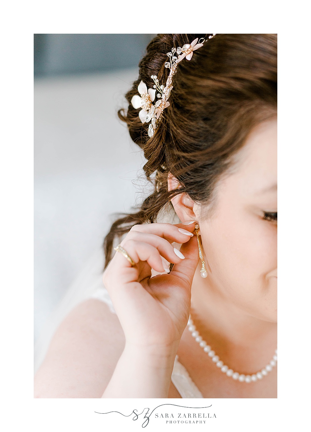 bride adjusts earrings before RI wedding 