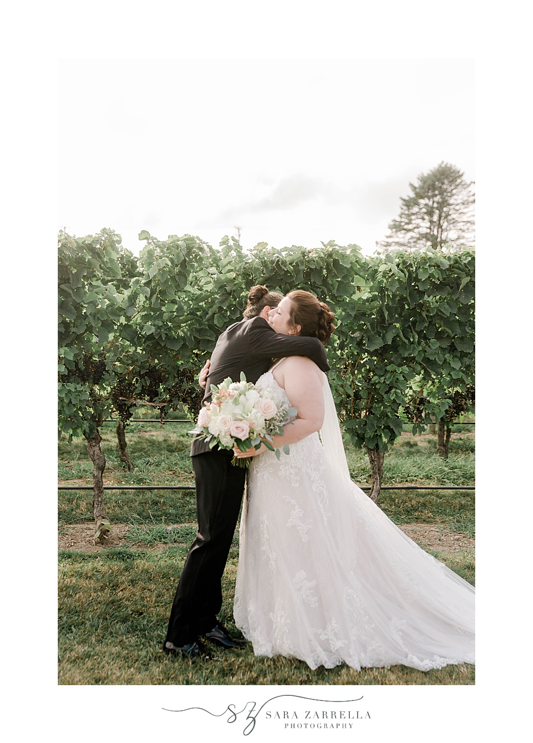 bride and groom hug among vines at Newport Vineyards