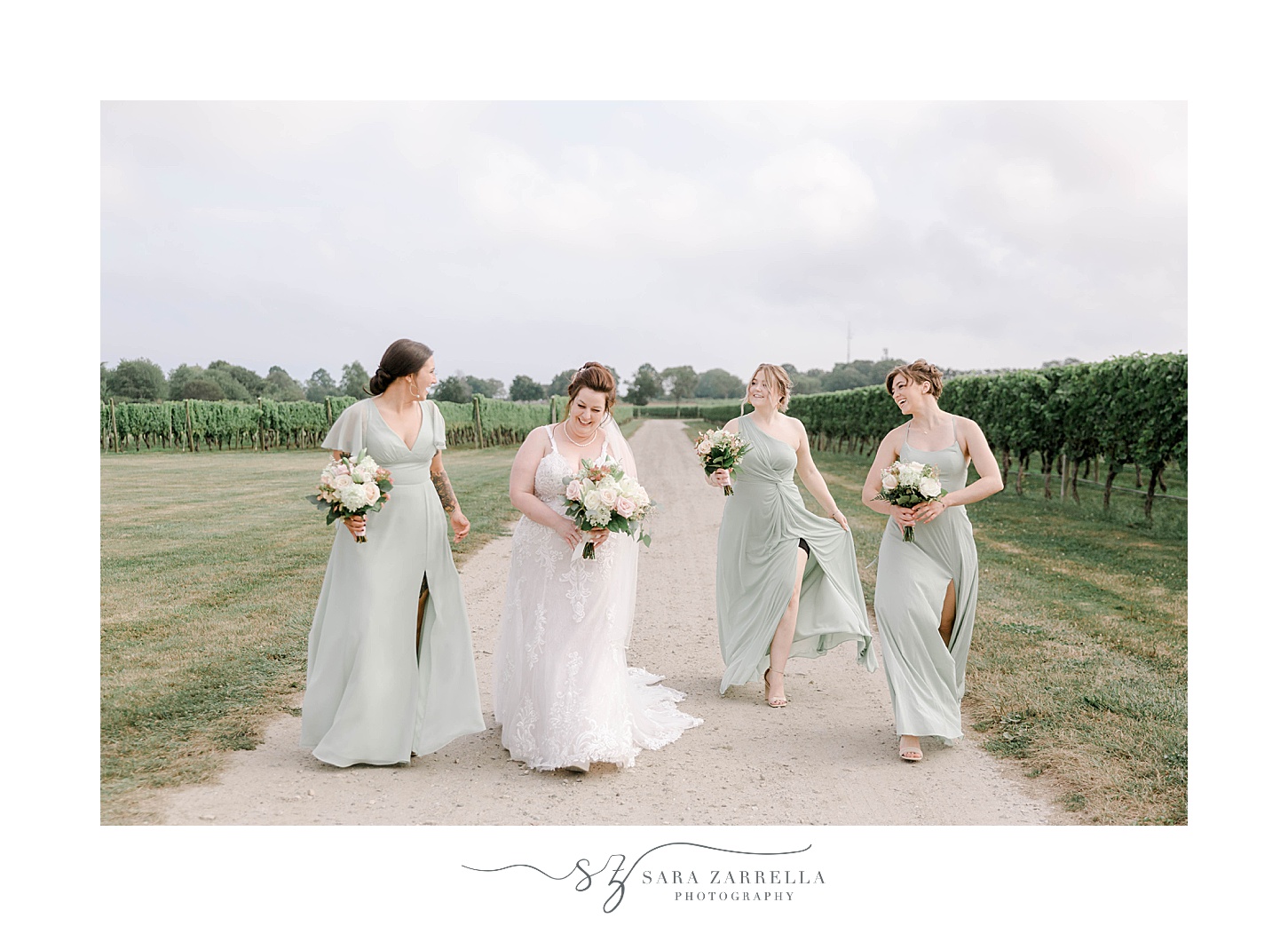 bride walks with bridesmaids in mint green gowns at Newport Vineyards