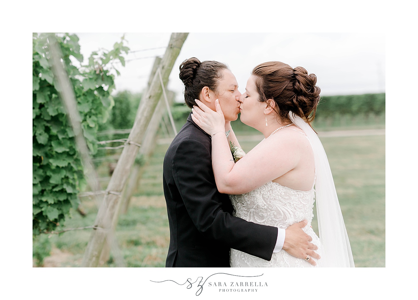 bride and groom kiss by wooden fence at Newport Vineyards
