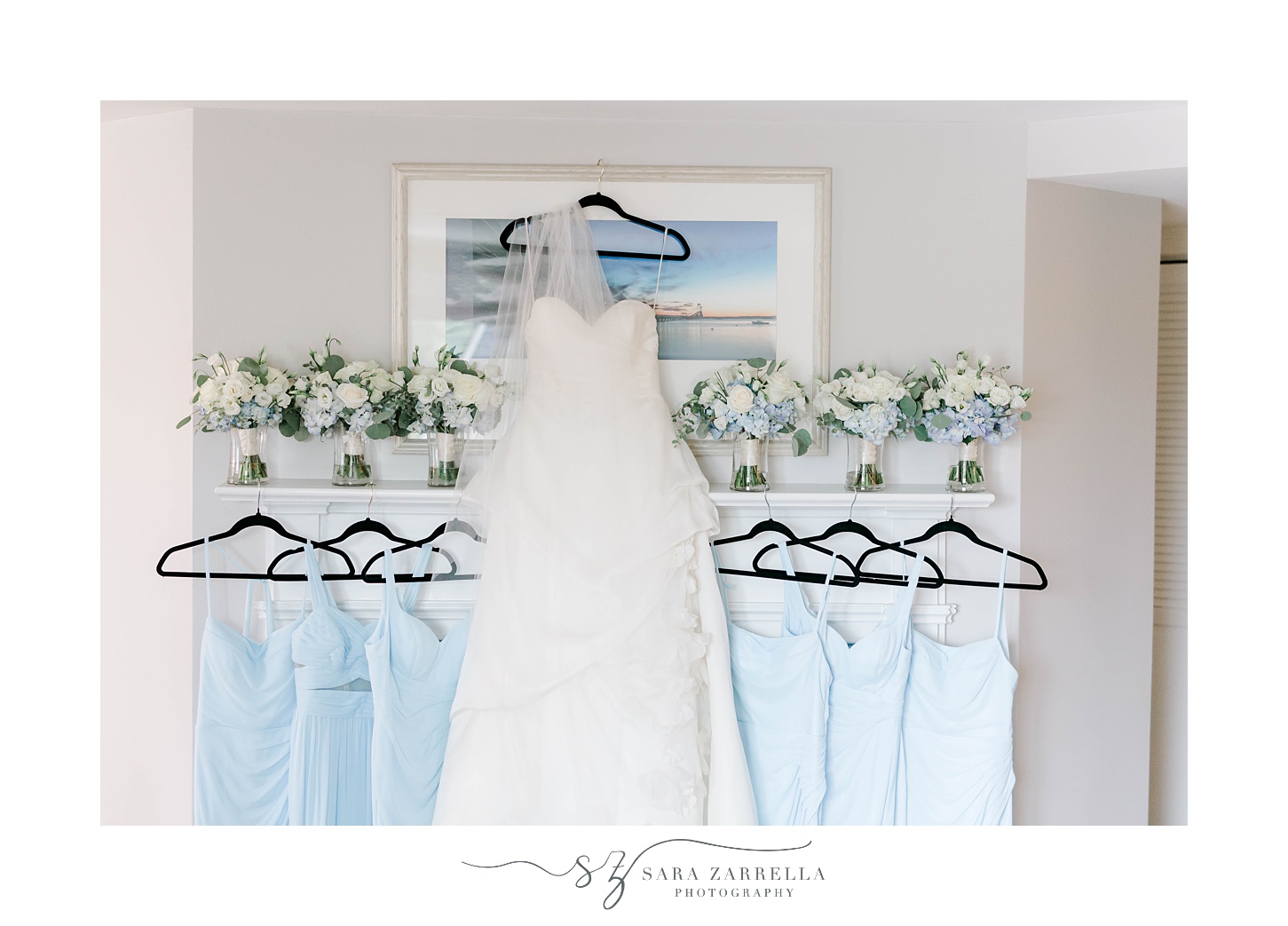 bride's wedding dress hangs on beach photo with blue bridesmaid dresses and blue and white bouquets