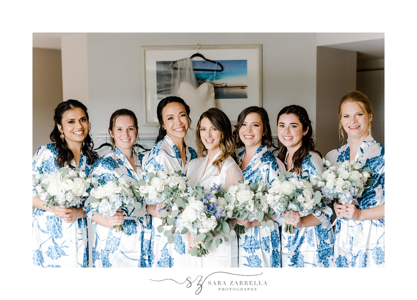 bride poses with bridesmaids in floral robes before Regatta Place wedding