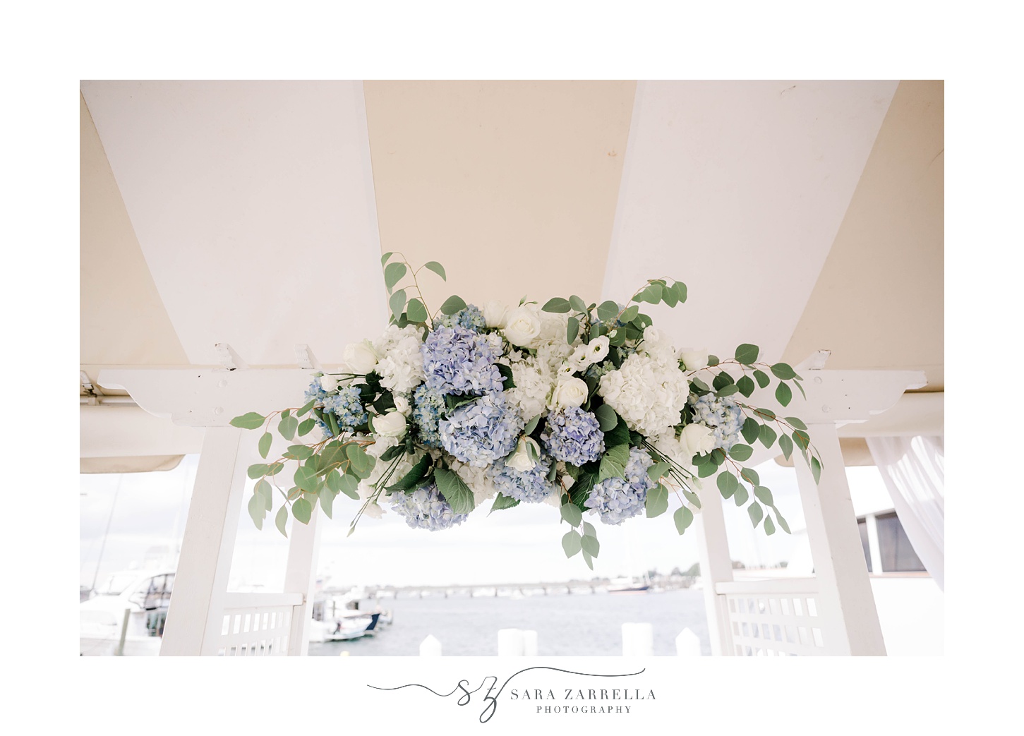 blue and white hydrangea rest on arbor during Regatta Place wedding ceremony