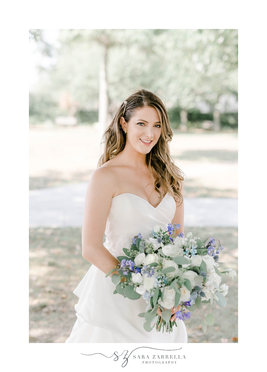 bride in strapless gown holds bouquet of white and purple flowers