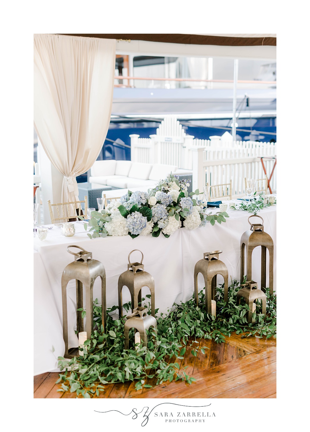 sweetheart table with greenery and lanterns in front
