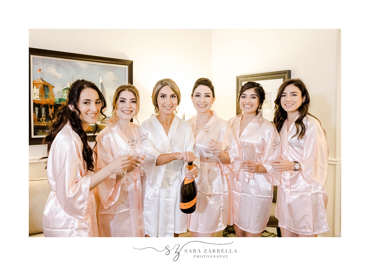 bride and bridesmaids in pink robes pose with champagne at the Viking Hotel