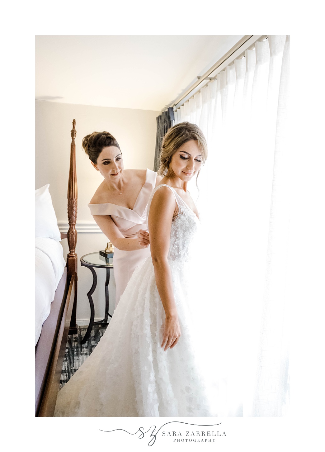 mother helps bride with back of wedding gown at the Viking Hotel