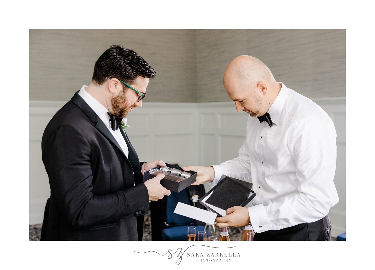 groomsman helps groom open gift on wedding day