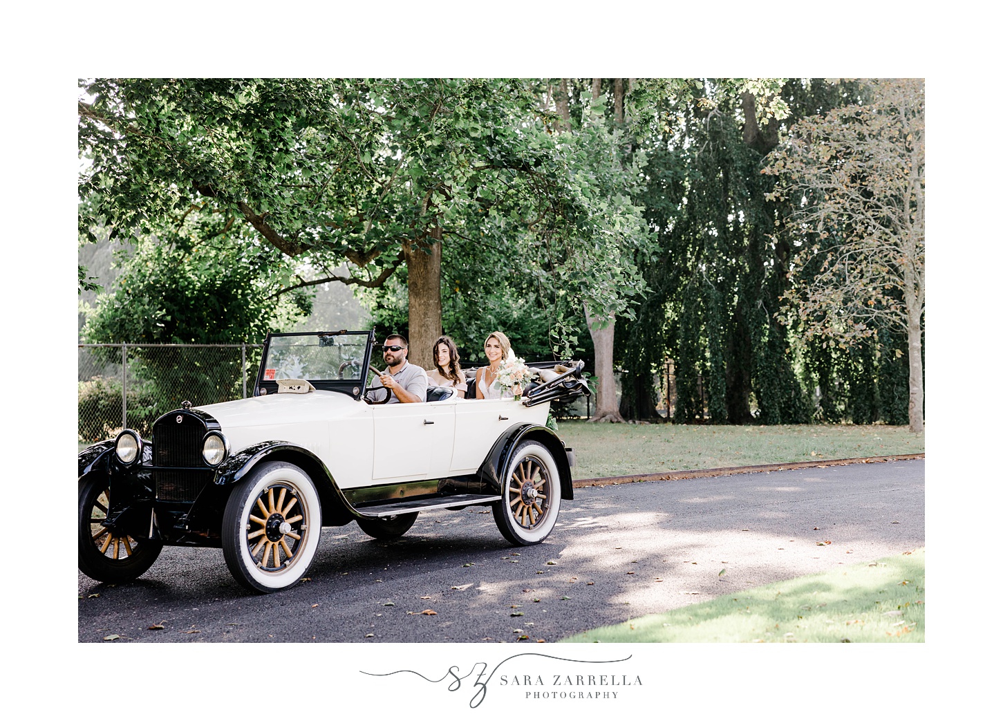 bride drives up to wedding at Rosecliff Mansion in classic car
