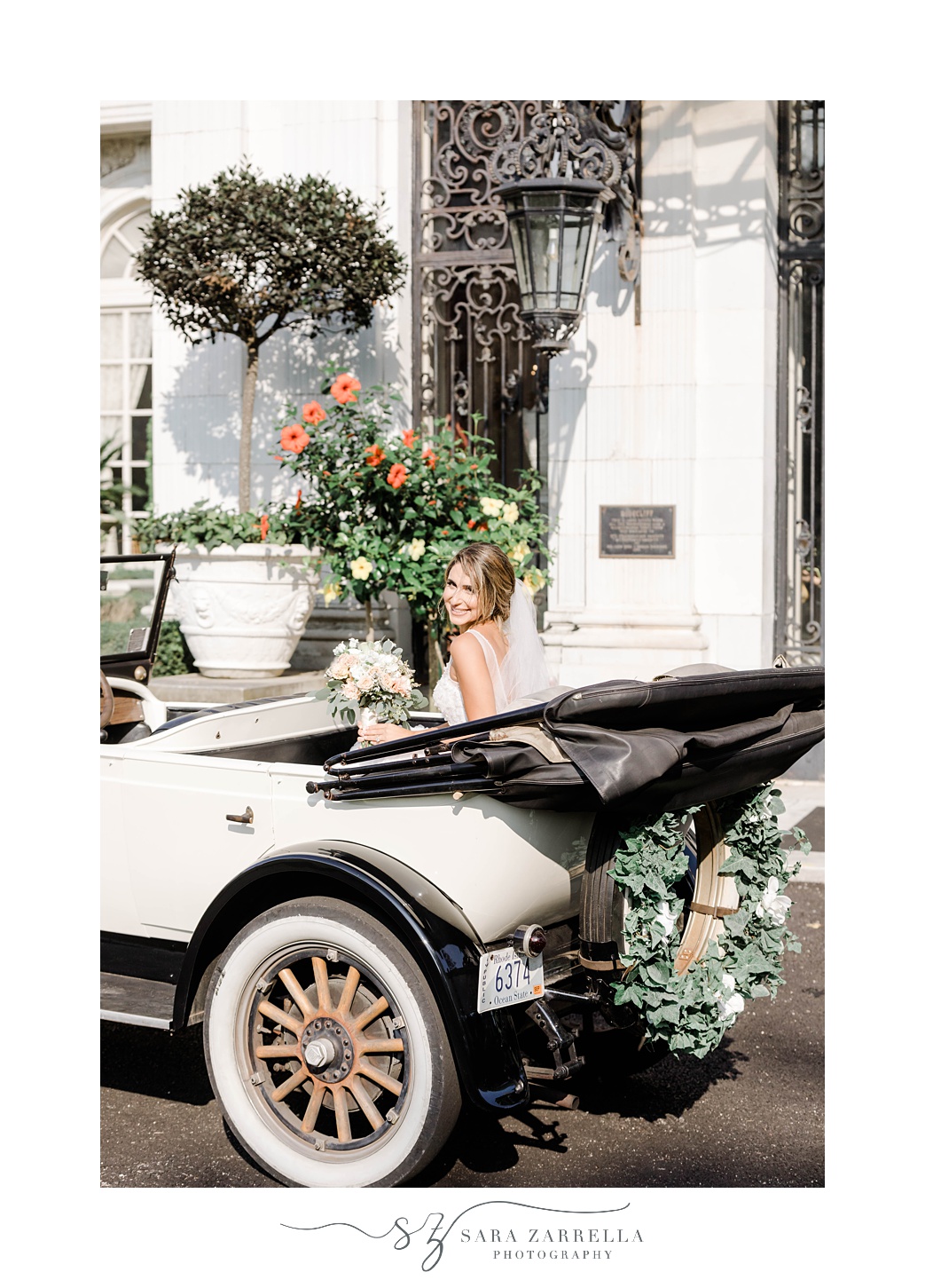 bride sits in classic car with top down at Rosecliff Mansion