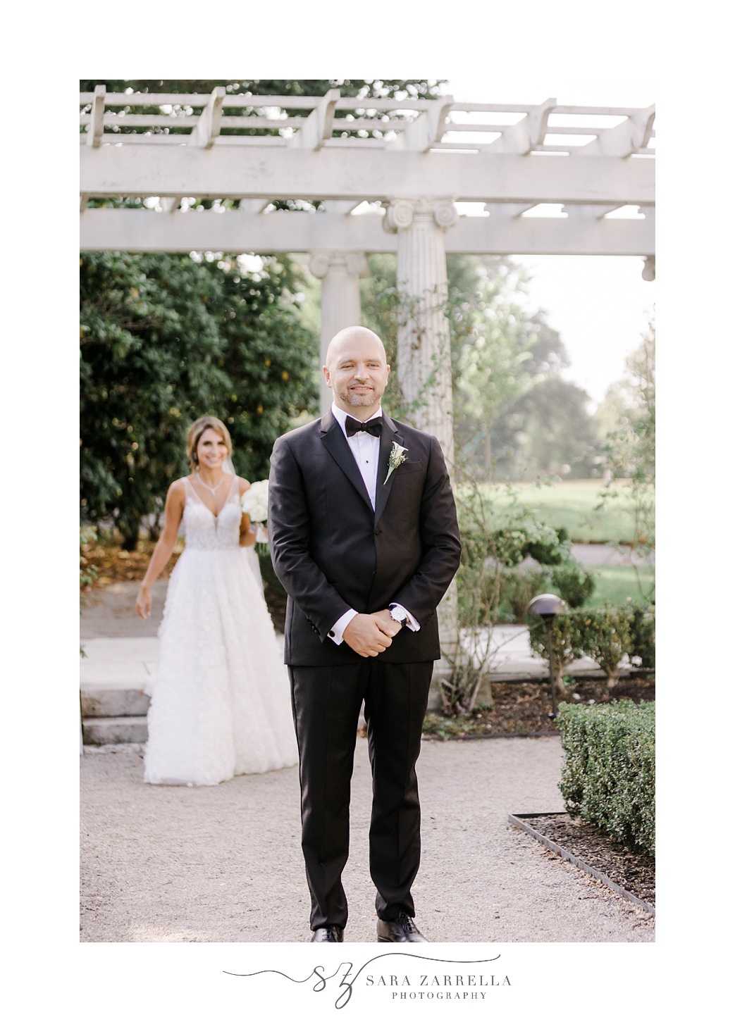 bride approaches groom for first look in Rosecliff Mansion garden