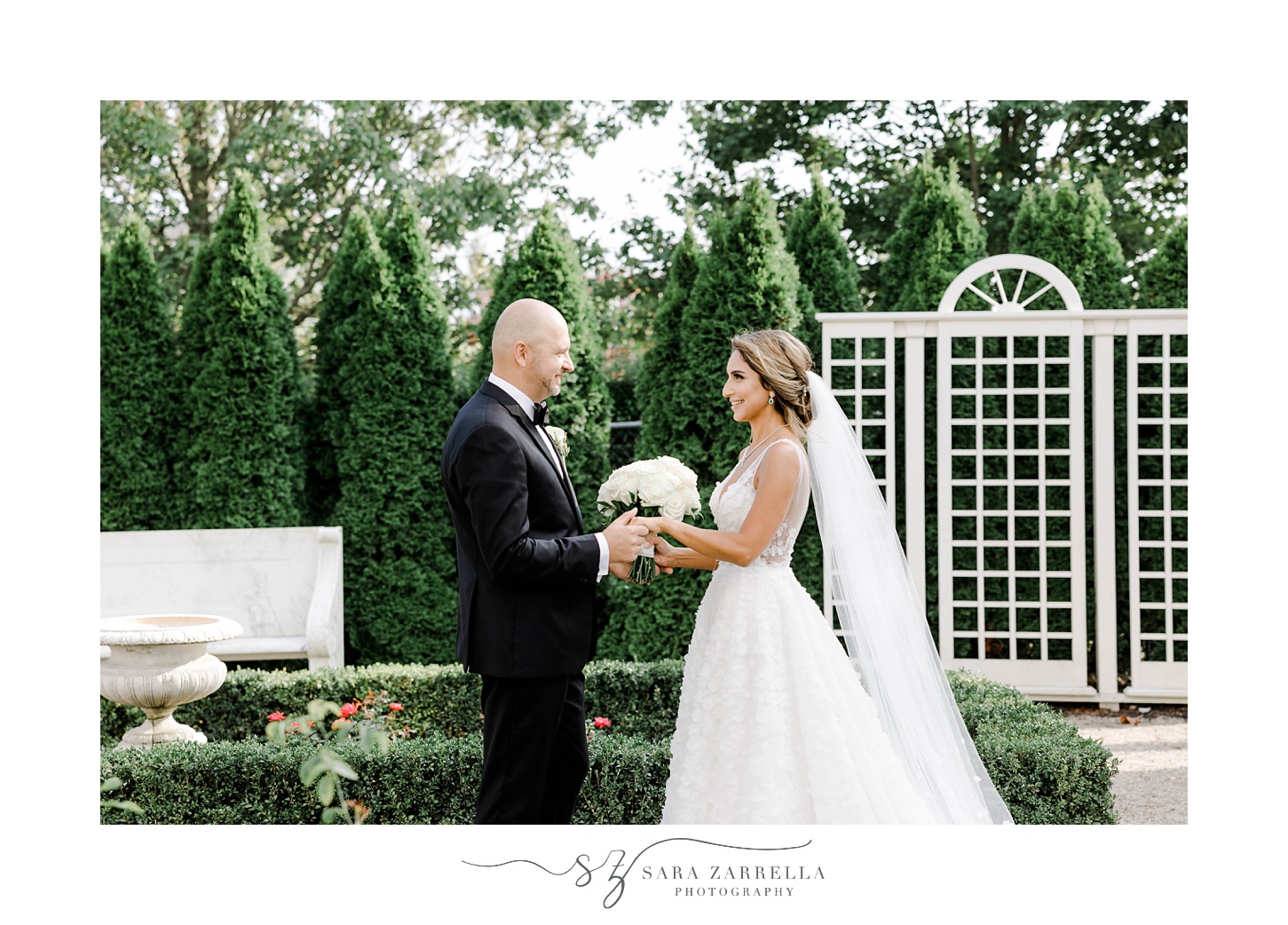 bride and groom smile in garden of Rosecliff Mansion during first look