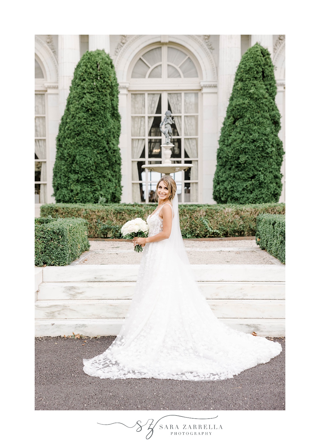 bride poses in front of window pane at Rosecliff Mansion