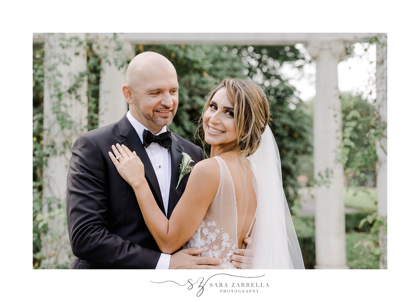 groom smiles at bride during portraits at Rosecliff Mansion