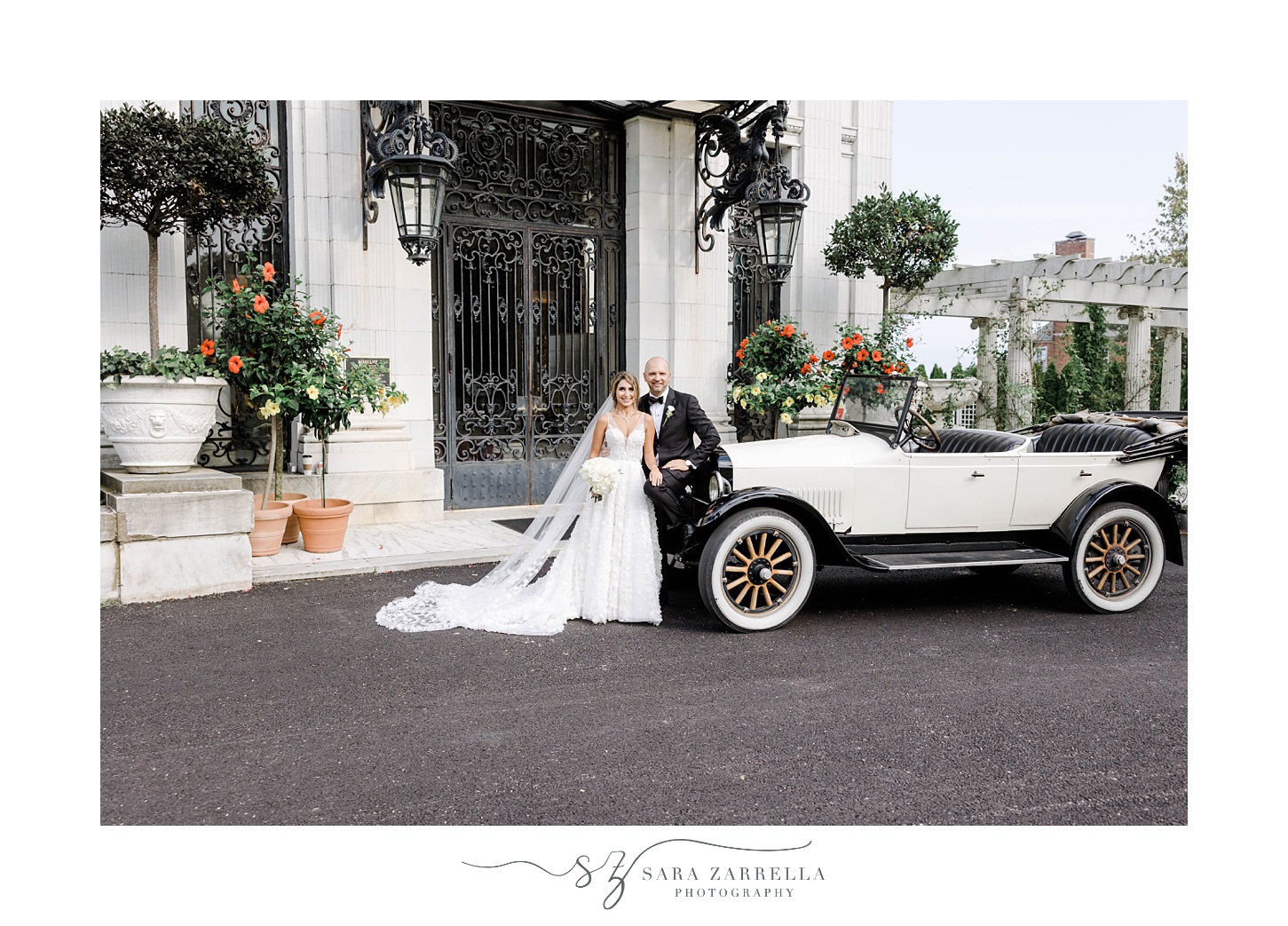 bride and groom pose by classic car outside Rosecliff Mansion