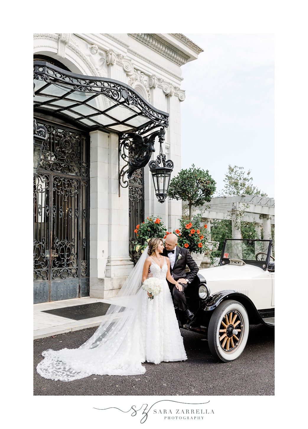 newlyweds pose by black and white classic car
