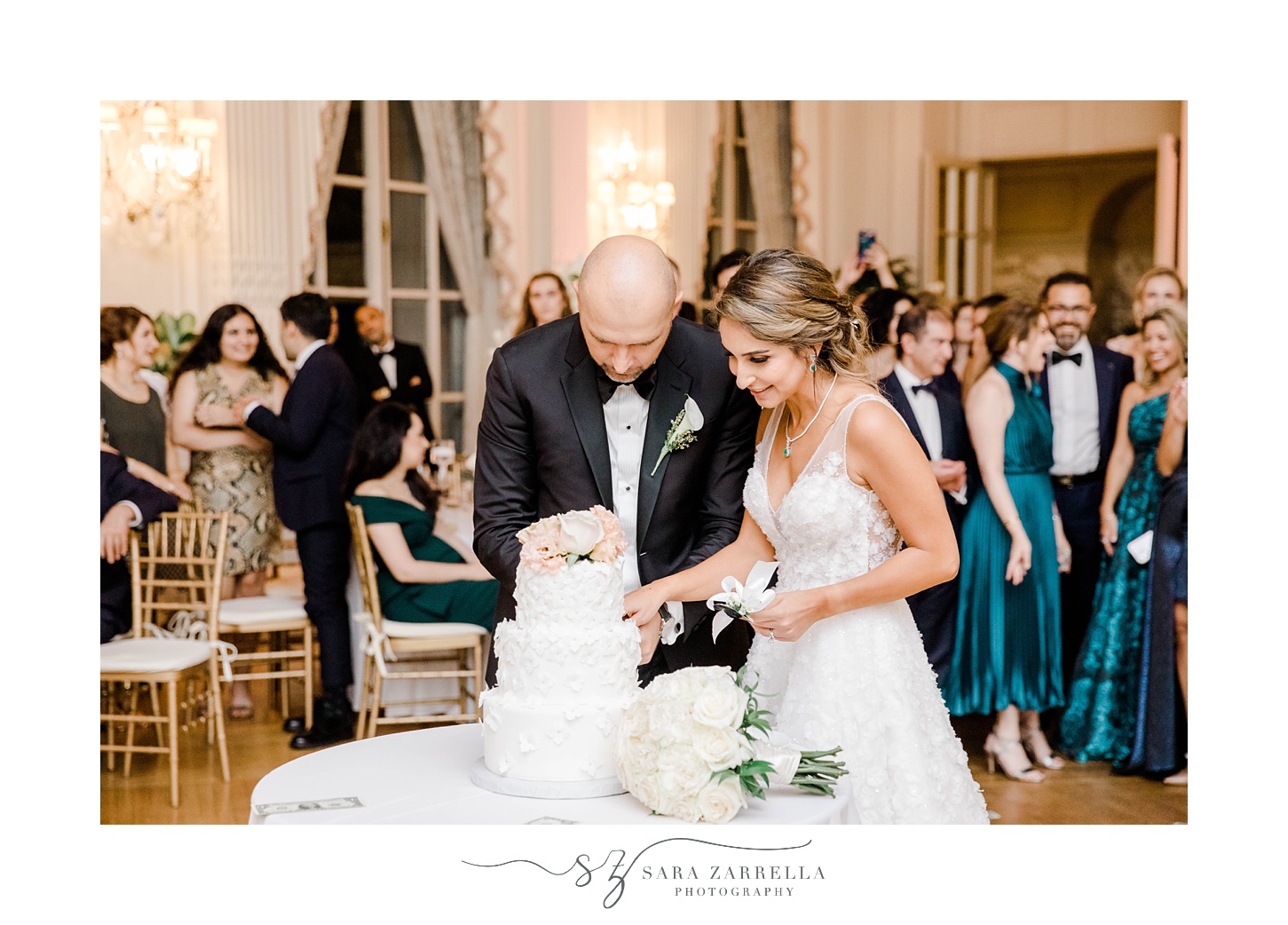 newlyweds cut wedding cake at Newport RI mansion wedding reception