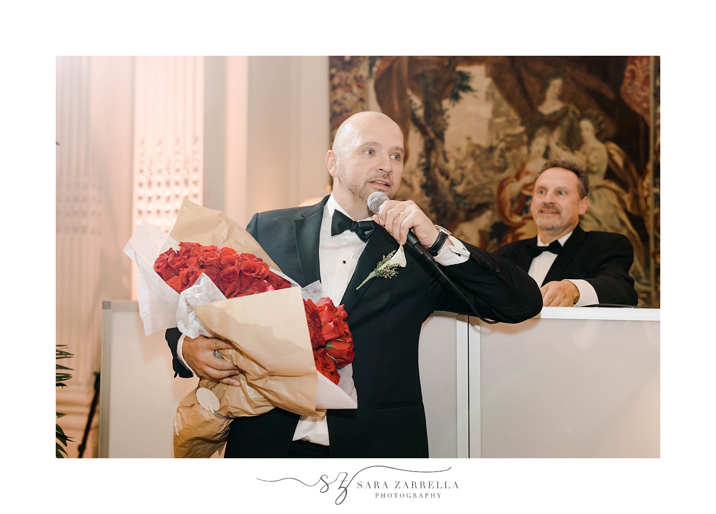 groom gifts toast holding red roses