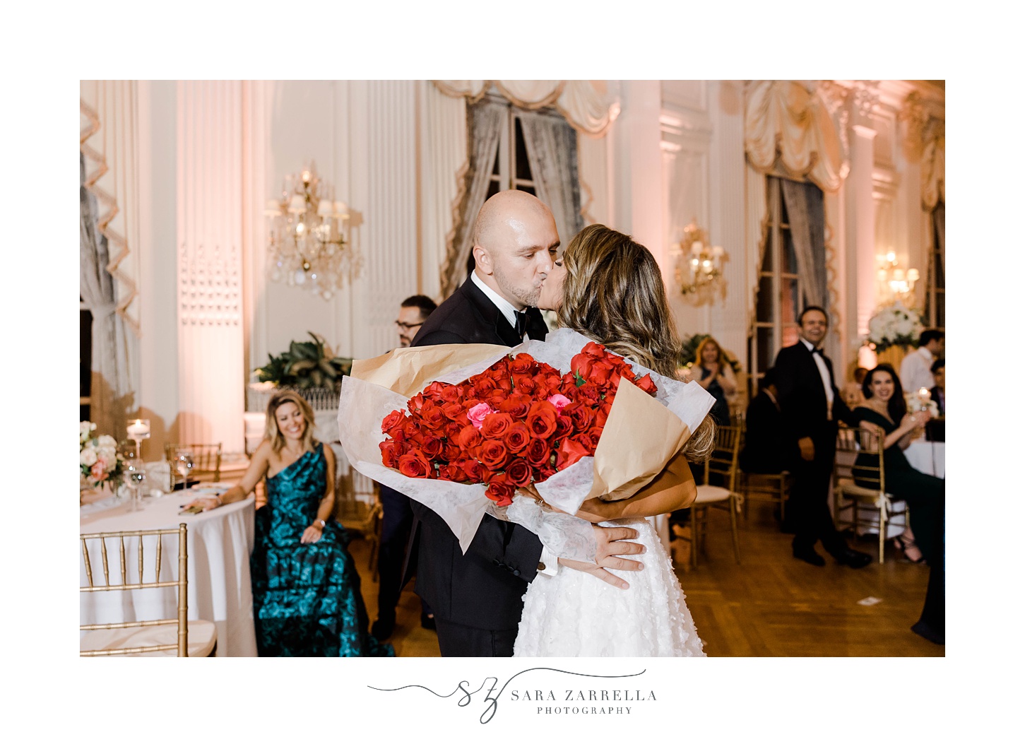 bride takes red roses from groom during reception