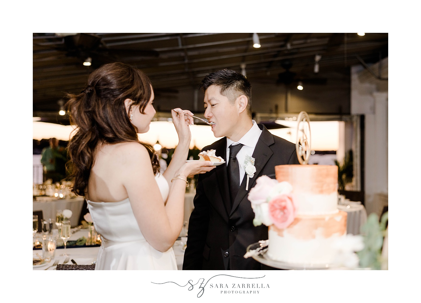 bride feeds groom cake during RI wedding reception 