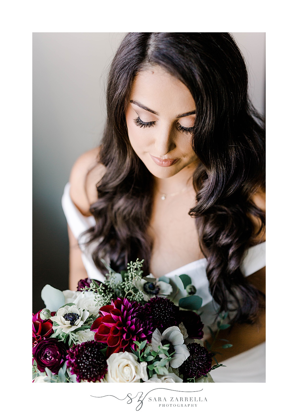 bride looks down at fall bouquet for RI wedding 