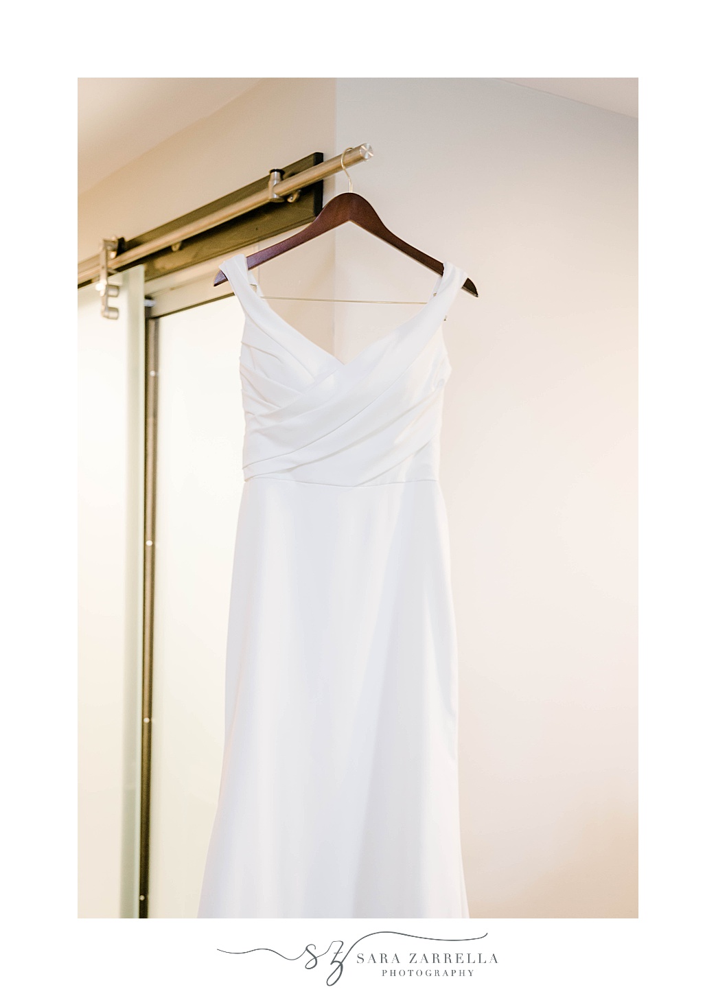bride's wedding dress hangs in hotel suite
