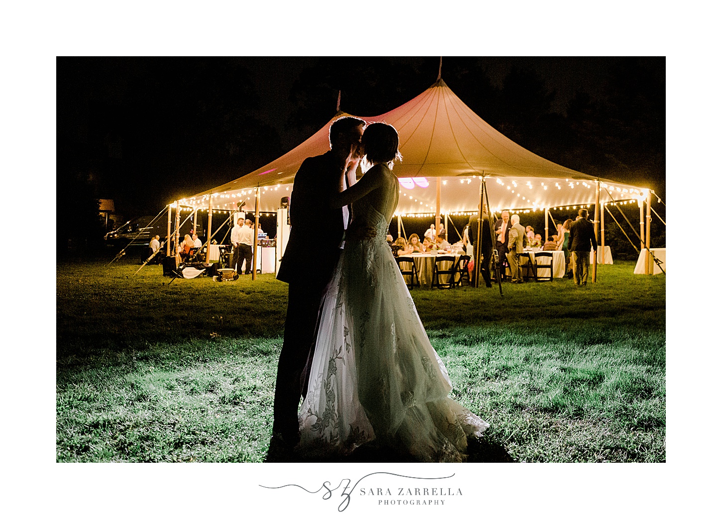 bride and groom kiss outside tent at night 